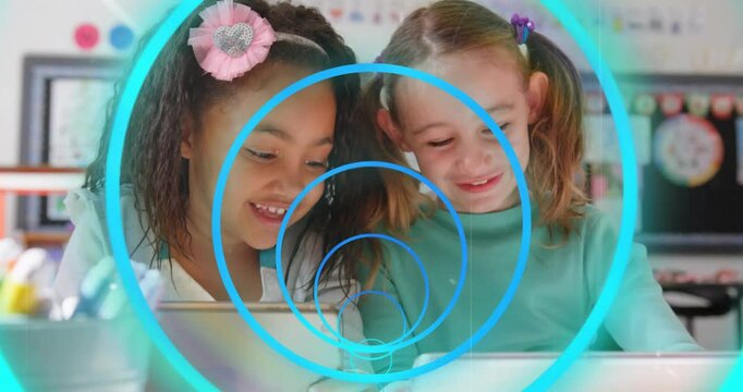 Two students tapping tablet and starting pulsing blue rings, leaning in and sharing learning