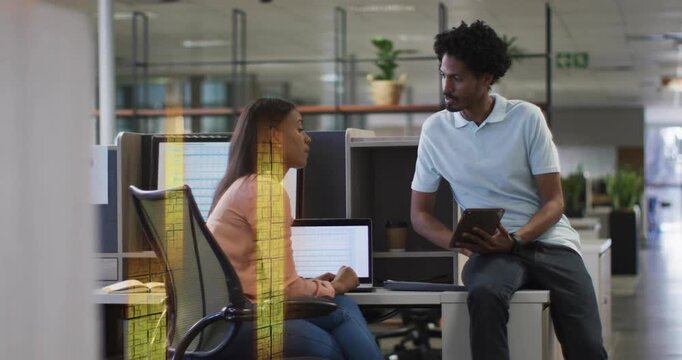 Woman pointing at laptop, man scrolling tablet, initiating business review as yellow bars sweeping