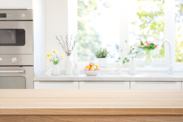 Wooden table top view for product presentation on blurred kitchen interior background with Easter...