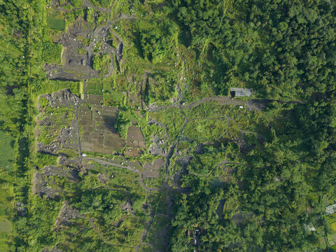 Aerial view of a rugged landscape interspersed with patches of vibrant greenery, creating a stark contrast between nature and terrain, Klaten Regency, Jawa Tengah, Indonesia.