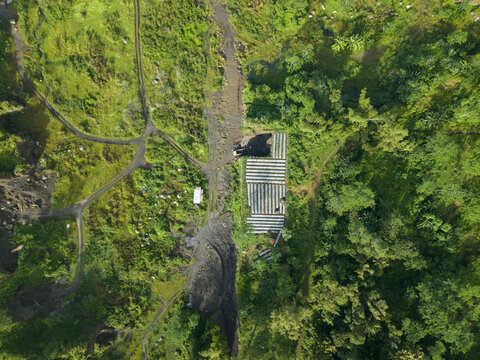 Aerial view of a stark contrast between industrial structures and lush green vegetation, a symphony of nature and human intervention, Klaten Regency, Jawa Tengah, Indonesia.