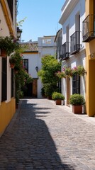 Fototapeta premium Narrow Cobblestone Street Framing Charming Architecture in Seville, Spain