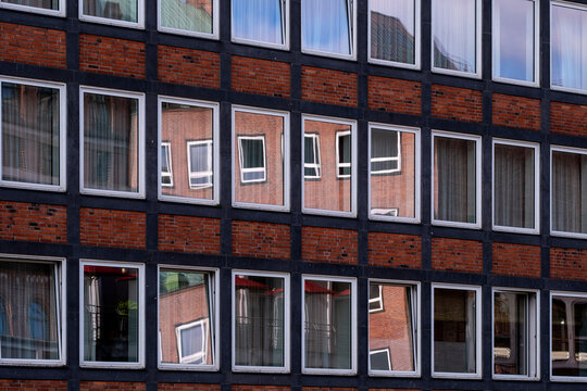 Urban modern architecture building exterior with brick facade and windows forming a grid pattern and crisp symmetry for contemporary design background