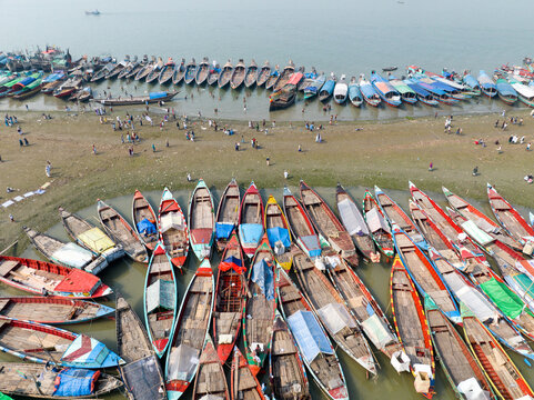 Aerial view of colorful boats clustered tightly together along the riverbank, creating a vibrant tapestry of hues against the muted tones of the water, Charmonai, Barisal Division, Bangladesh.