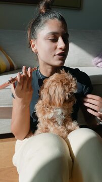 Calm scene of woman talking with puppy resting on her legs