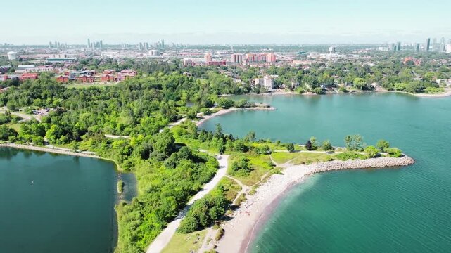 Aerial drone view of Colonel Samuel Smith Park waterfront with Toronto skyline in the distance, Etobicoke, Canada &ndash; 14 September 2026 &ndash; lakeside greenery and urban skyline under clear sky cinematic 4K