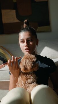 Youthful woman peacefully cradles her fluffy dog in sunlight