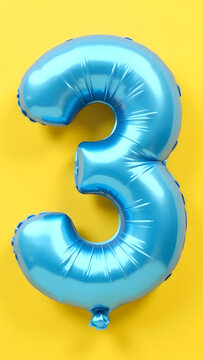 Bright blue balloon in the shape of the number three on a yellow background