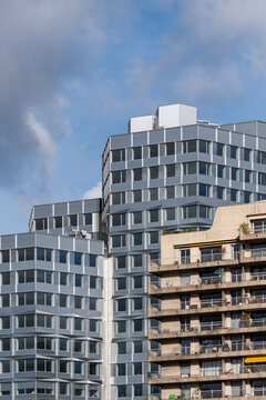 Modern apartment tower architecture with repeating balcony lines in Paris France against a cloudy sky presenting urban residential housing and geometry