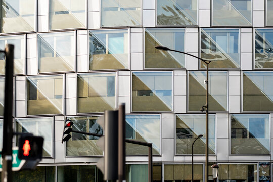 Glass facade architecture in Paris France showing modern pattern and reflections with an urban trafficlight creating geometric city street detail