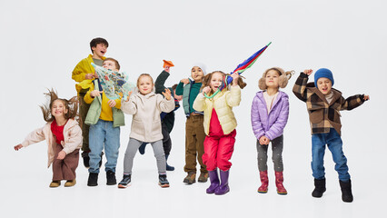 Obraz premium Group of children posing in trendy autumn fashion clothes in studio. Concept of kids fashion collection, seasonal apparel style and modern children clothing presentation.