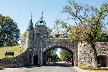 Quebec City, Canada - August 23, 2025: Porte Saint-Louis stone city gate with green copper turrets and road passing under arch on sunny day © Andrei Antipov