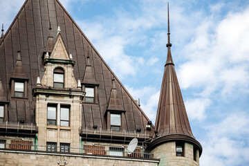 Quebec City, Canada - August 23, 2025: Close-up architectural details of Fairmont Le Chateau Frontenac hotel towers, green copper roofs, turrets and brick stone facade elements © Andrei Antipov