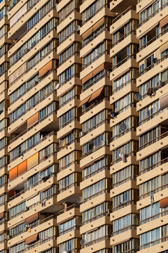 Architecture facade of a residential apartment building with repeating windows forming pattern repetition and a clear grid geometry as texture in spain