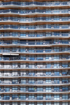 Architecture facade with balconies and windows on a residential apartment block featuring pattern repetition and symmetry as abstract city texture in spain