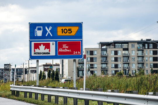 Montreal, Canada - August 24, 2025: Highway services sign showing Petro Canada gas station and Tim Hortons restaurant near Montreal
