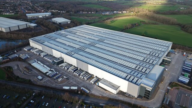 Tamworth, United Kingdom - 21 February 2026: Aerial view of the vast, sprawling LKQ Euro Car Parts (ECP) T2 facility, a symphony of grey and white against a backdrop of green fields.