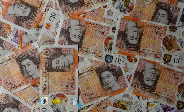 Scattered 10 Pound Sterling Notes on Table