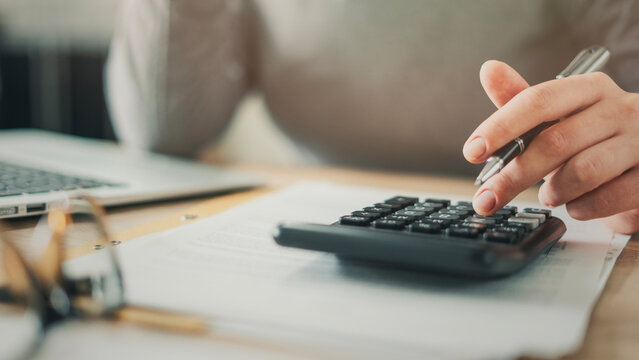 Close-up view woman's hand using a calculator