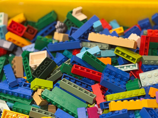 Naklejka premium Colorful plastic building bricks in a bin