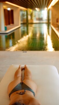 Female lying back in swimwear reflecting serene poolside atmosphere