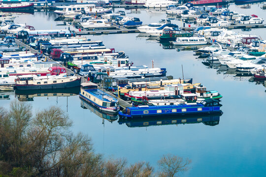 Aerial view of a vibrant harbor filled with an array of boats and yachts, reflecting the clear sky in the calm waters, creating a picturesque scene., Reading, Berkshire, United Kingdom.