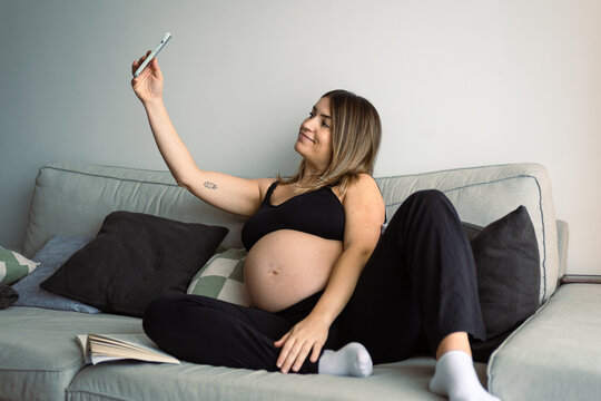 pregnan woman using phone at home