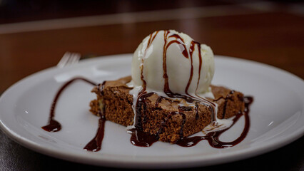 Brownie de chocolate caliente con bola de helado de vainilla y sirope de chocolate