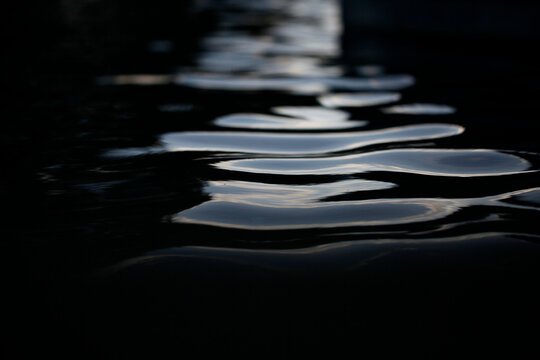 Serene water surface with gentle ripples under soft light