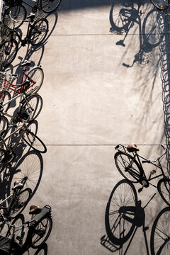 Overhead view of bicycles parking creating shadows pattern on pavement with urban transport texture in Stockholm Sweden daylight