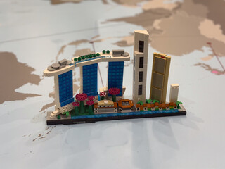 Fototapeta premium Toy brick miniature skyline on world map background