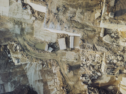 Aerial view of a sprawling quarry, the earth scarred with geometric cuts and piles of stone, a testament to human industry, Porrino, Pontevedra, Spain.