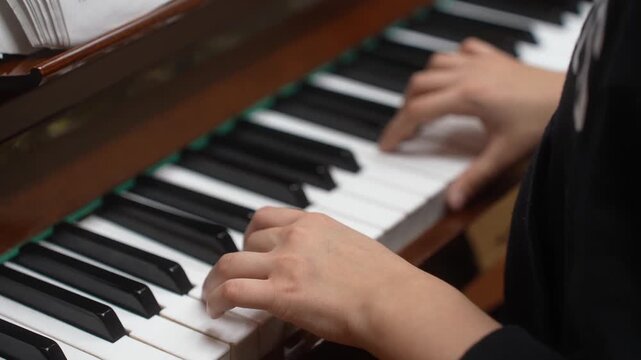 Young kid playing piano, closeup. Music school lesson