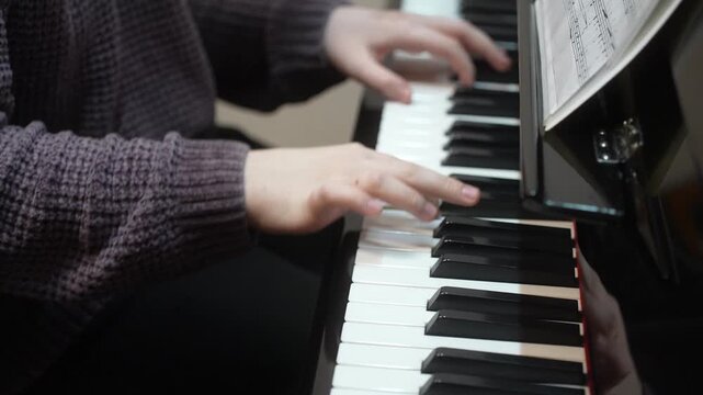 Young kid playing piano, closeup. Music school lesson