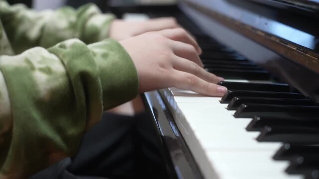 Young kid playing piano, closeup. Music school lesson