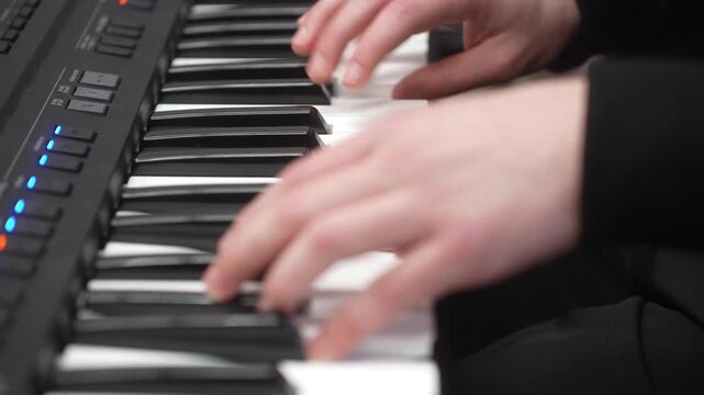 Young kid playing synthesizer, closeup. Music school lesson