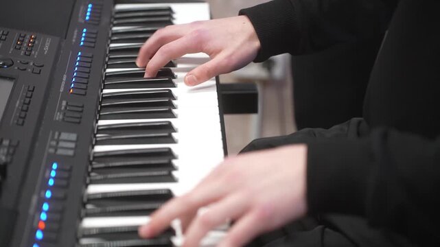 Young kid playing synthesizer, closeup. Music school lesson