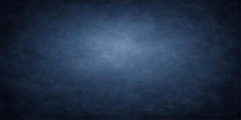 A blank, dark blue vintage grunge background features an aged, textured pattern reminiscent of a rough, dirty chalkboard or an empty old paper surface for design wallpaper © suriyaakter