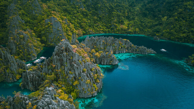 Aerial view of jagged limestone cliffs meet the turquoise waters, a tropical paradise of contrasting textures and vibrant colors, Palawan, Palawan, Philippines.