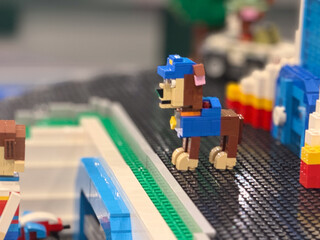Naklejka premium Lego brick dog figure in colorful toy city scene