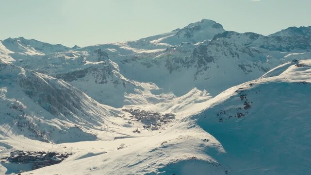 drone footage of france alps ski resort with snow mountains and people skiing