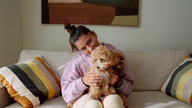 Woman cuddles puppies. Joyful woman embraces two adorable fluffy dogs