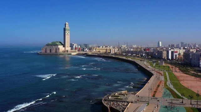 Aerial view of Casablanca waterfront with Hassan II Mosque along Atlantic coast in Morocco showing ocean waves urban skyline and seaside promenade