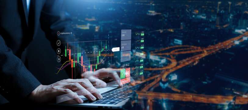 Business professional analyzing financial market data on laptop with virtual trading dashboard and candlestick chart over city night background. stock trading, cryptocurrency investment