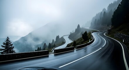 Naklejka premium Winding mountain road through a misty forest, showcasing a dramatic and atmospheric scene of a wet highway curving through lush evergreen trees and shrouded hillsides.