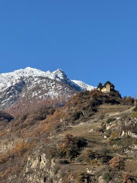 Panorama mountain landscape in Naturns in South Tyrol in autumn, in the background the snow-covered mountains, blue sky with clouds, no people