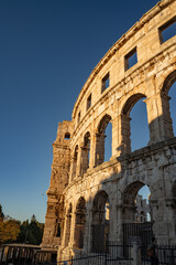 Fototapeta premium Close-up of ancient Roman stone arches of Pula Arena, historic limestone walls of the amphitheater in Istria, Croatia, architectural detail
