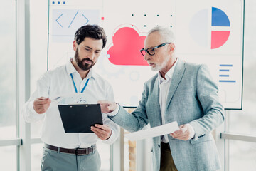Business partners review charts and papers during a meeting in a modern office