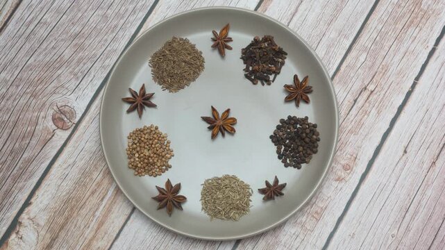 Spices arranged in a circle on a gray plate. Top view, flat lay
