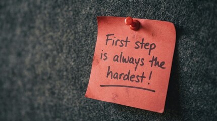 Red sticky note with handwritten motivational quote First step is always the hardest message pinned on board